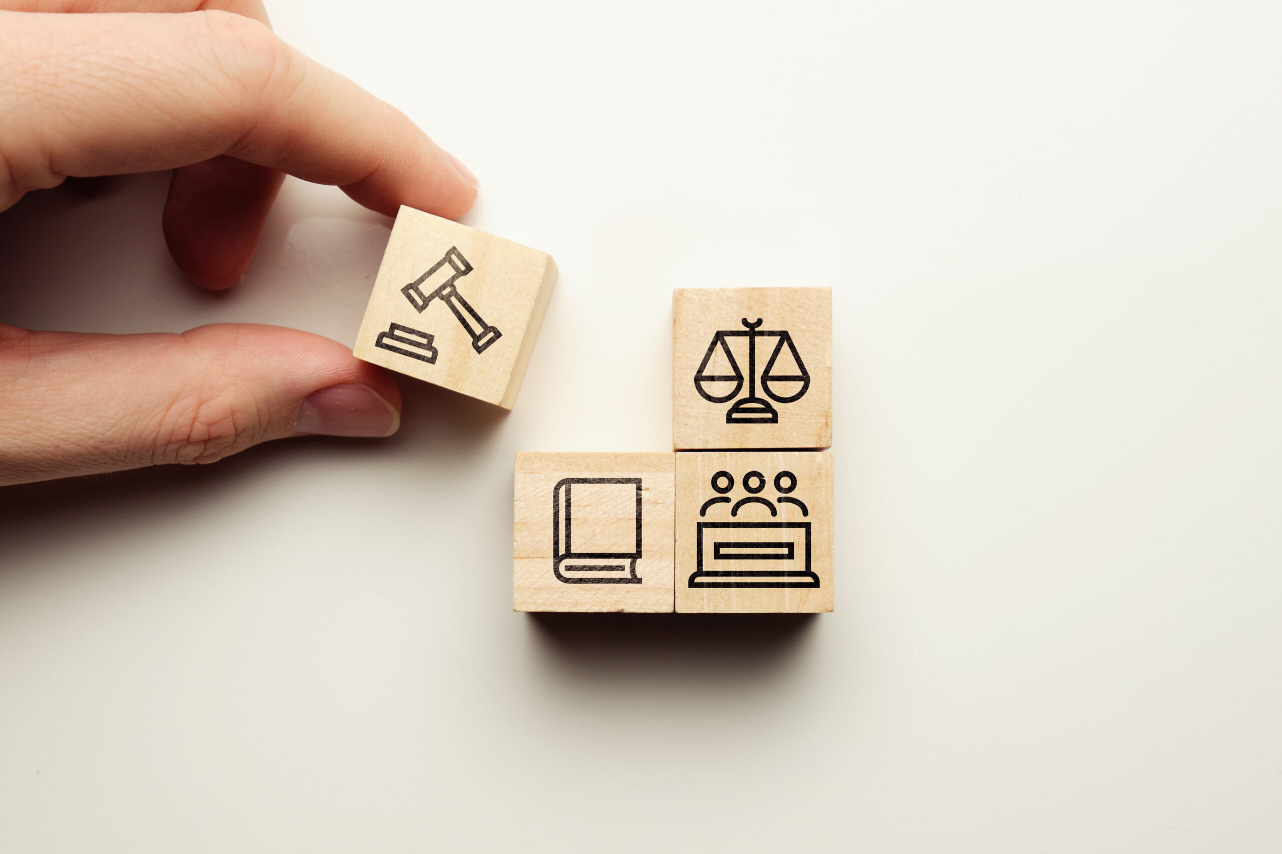 Lawsuit concept with witness icons, law book on wooden cubes. Via Freepik.com